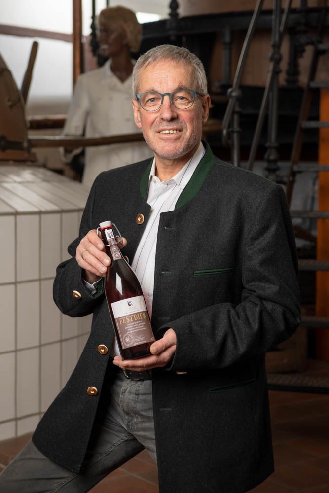 Dipl. Ing. Martin Knab, 1. Vorsitzender Fränkisches Brauereimuseum, mit einer Flasche des Michaelsberger Festbiers